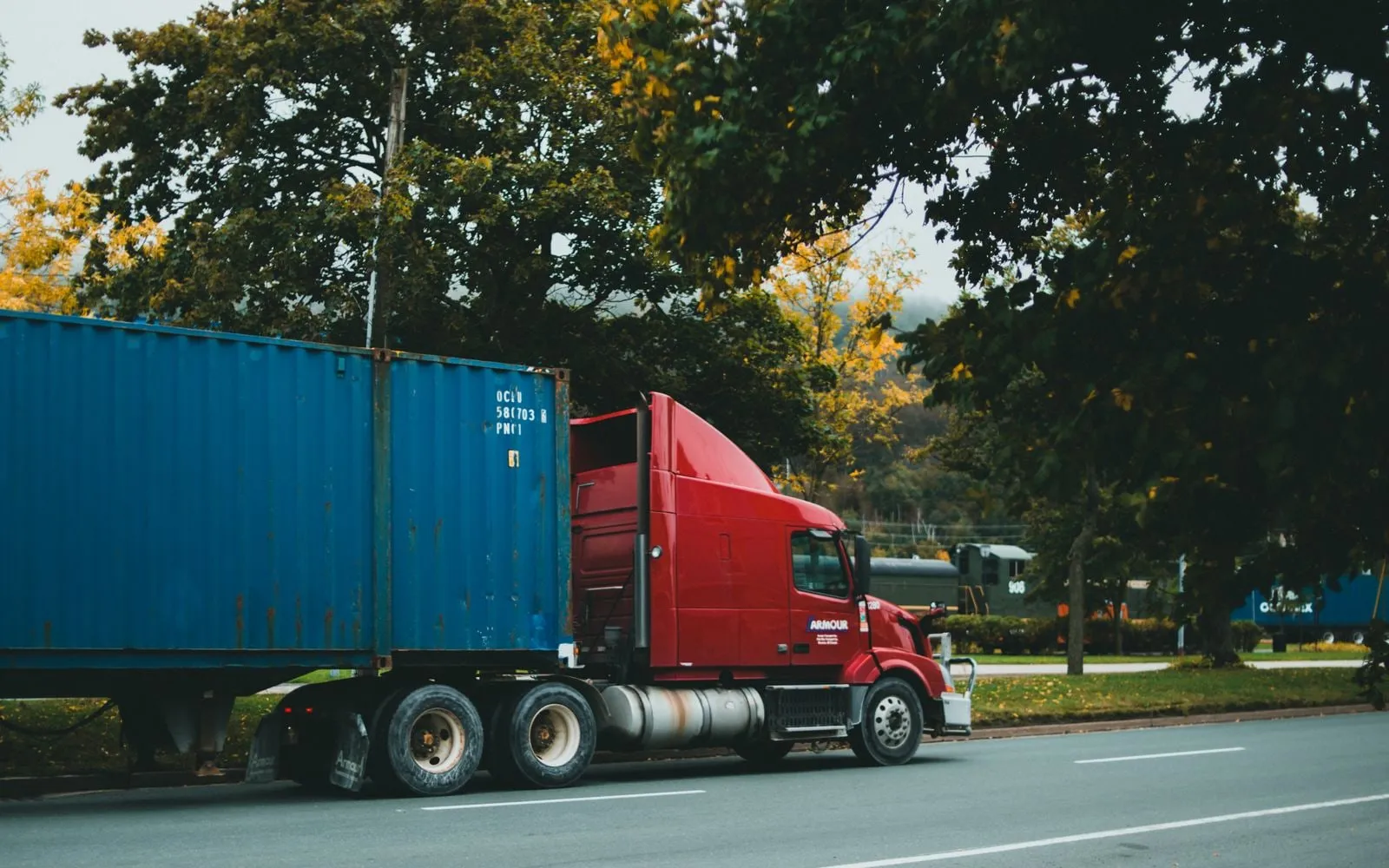 Xe đầu kéo chở container xanh chạy trên đường quốc lộ