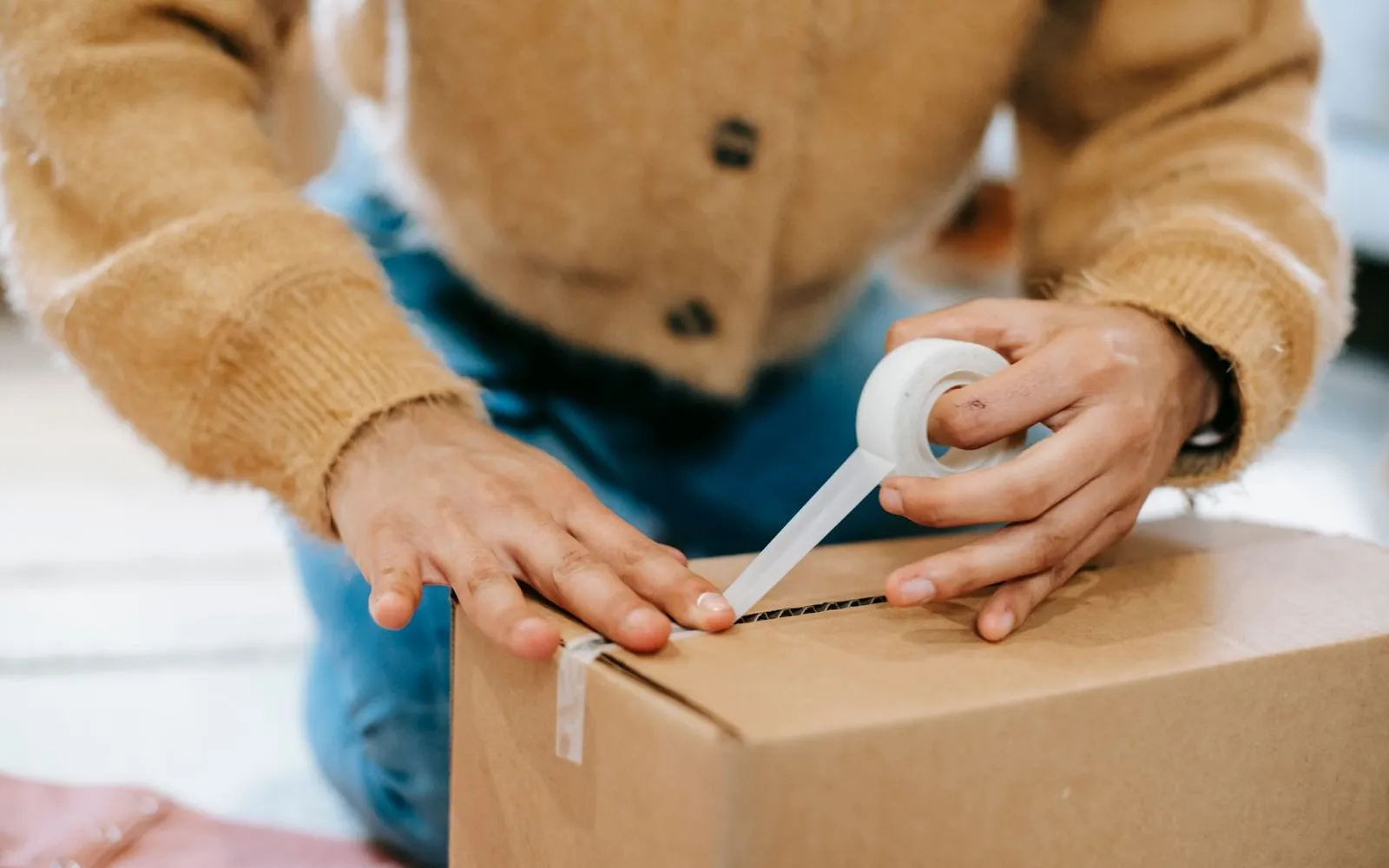Nhân viên dán băng keo niêm phong thùng carton trước khi gửi hàng
